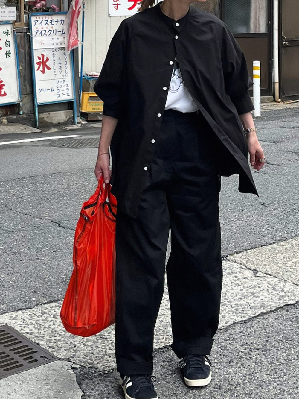 ブラック系のシャツ/ブラウス、ブラック系のチノパンツ、ブラック系のスニーカーを着用したレディースの春コーディネートの2枚目の写真