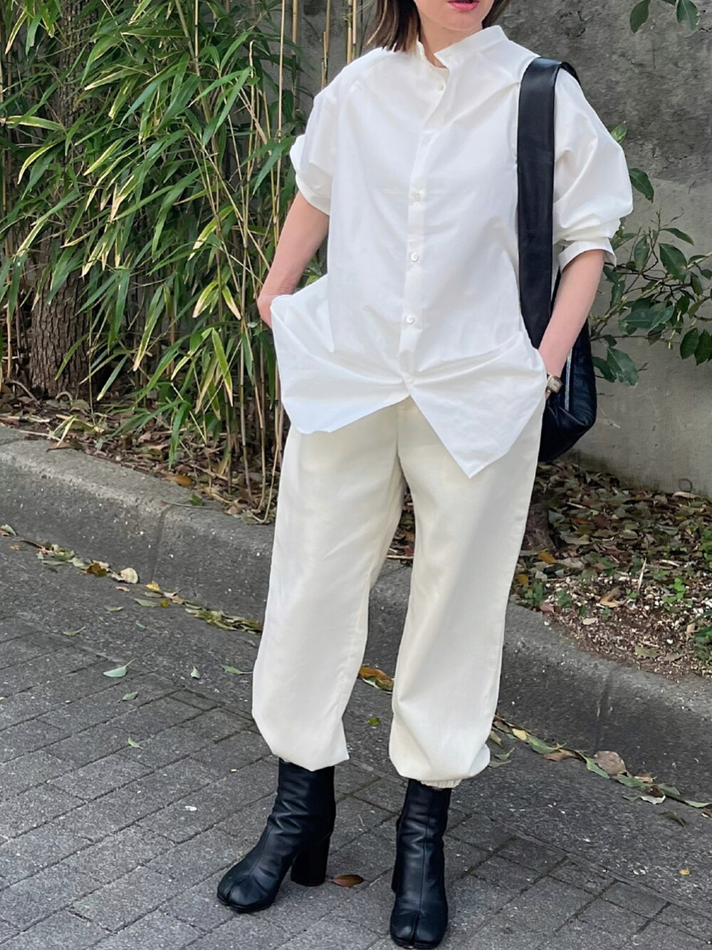 ホワイト系のシャツ/ブラウス、ホワイト系のパンツ、ブラック系のブーツを着用したレディースの春コーディネートの2枚目の写真