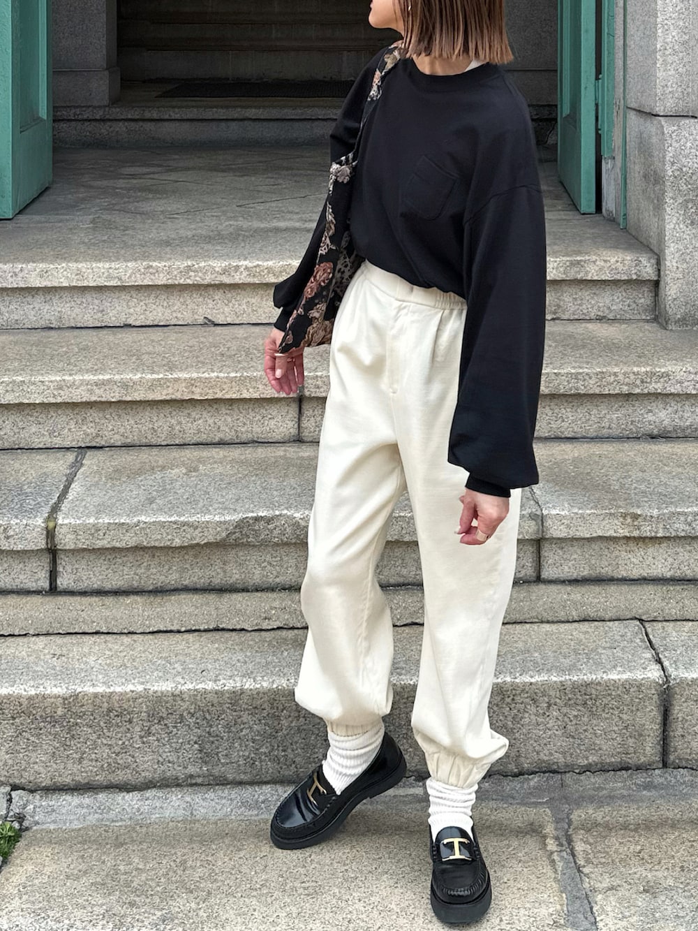 ブラック系のTシャツ/カットソー、ホワイト系のパンツ、ブラック系のローファーを着用したレディースの冬コーディネートの5枚目の写真