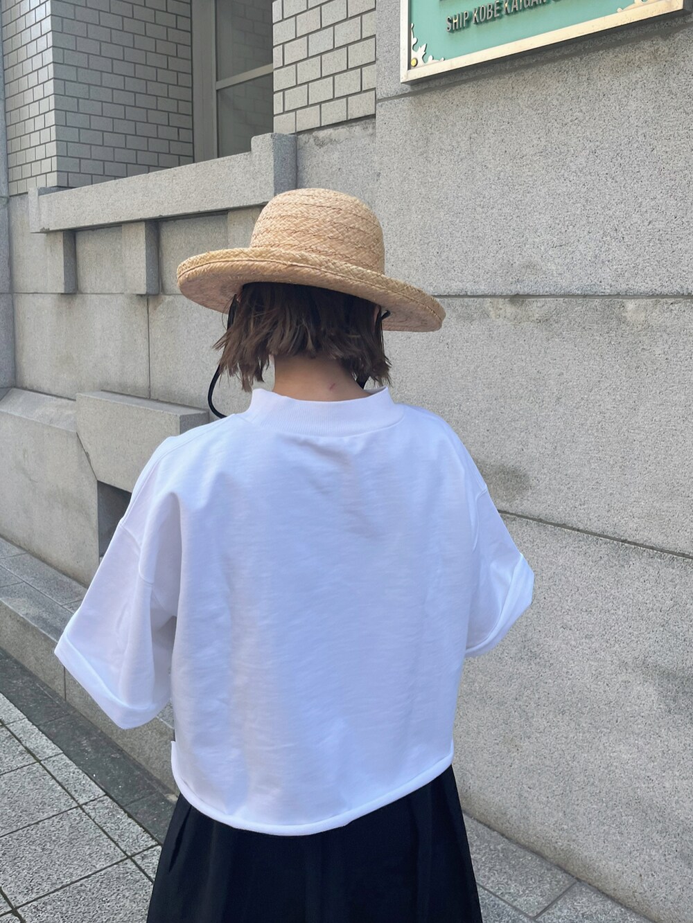 ホワイト系のTシャツ/カットソー、ブラック系のハット、シルバー系のブレスレットを着用したレディースの夏コーディネートの5枚目の写真
