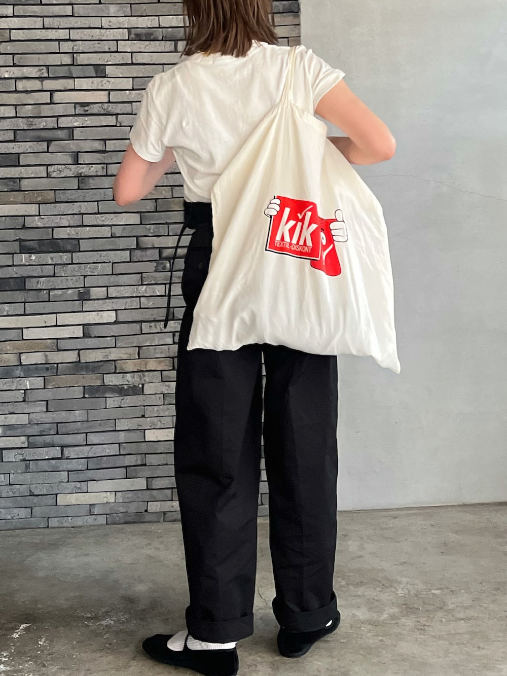 ブラック系のチノパンツ、ブラック系のその他シューズ、ブラック系のボストンバッグを着用したレディースの冬コーディネートの5枚目の写真