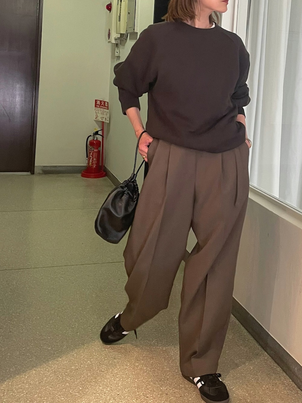 ブラック系のスウェット、グリーン系のパンツ、ブラック系のスニーカーを着用したレディースの夏コーディネートの4枚目の写真