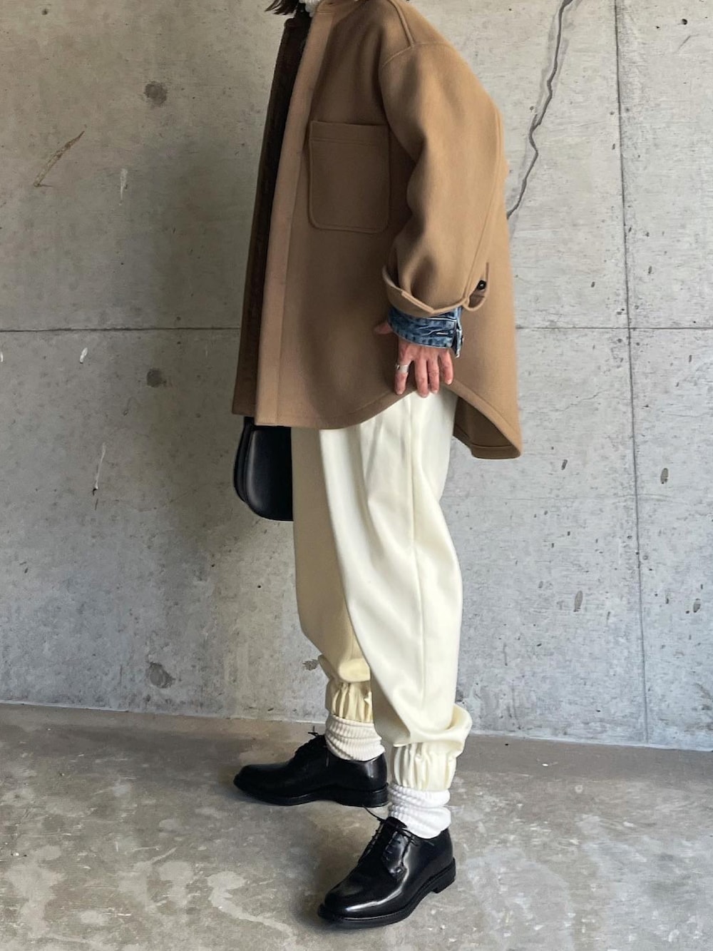 ブラウン系のジャケット/アウター、ホワイト系のパンツ、ブラック系のドレスシューズを着用したレディースの秋コーディネートの2枚目の写真