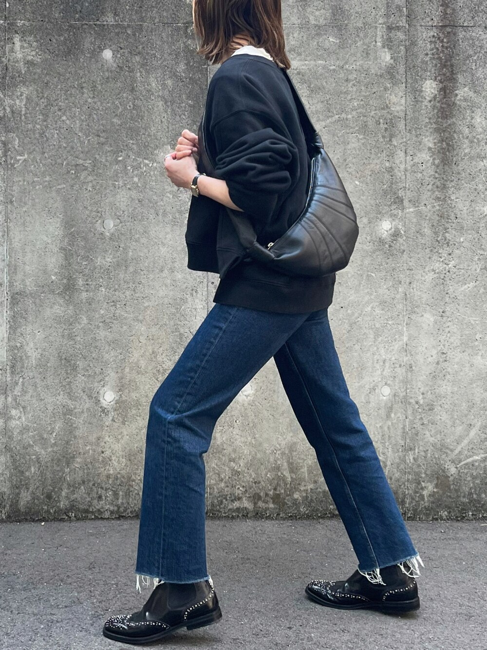 ブラック系のショルダーバッグ、ブラック系のブーツを着用したレディースの春コーディネートの4枚目の写真