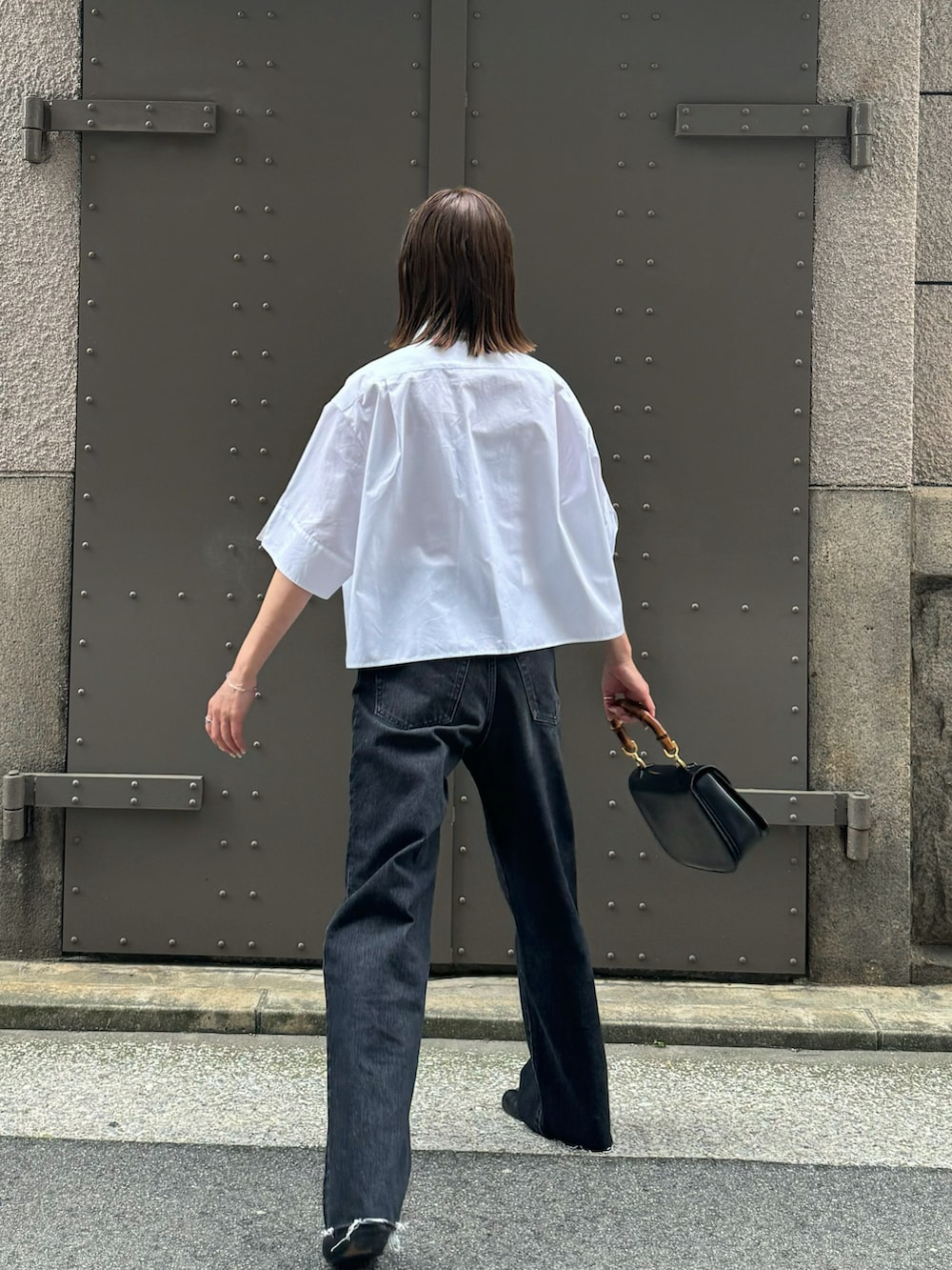 ブラック系のデニムパンツ、ホワイト系のシャツ/ブラウス、ブラック系のバレエシューズを着用したレディースの春コーディネートの2枚目の写真