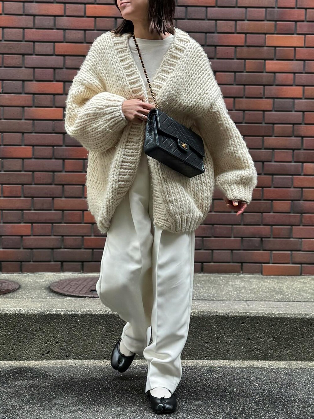 ホワイト系のパンツ、ブラック系のバレエシューズ、シルバー系のリングを着用したレディースの冬コーディネートの3枚目の写真