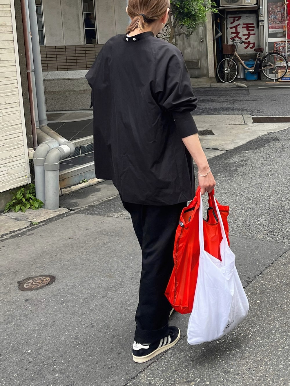 ブラック系のシャツ/ブラウス、ブラック系のチノパンツ、ブラック系のスニーカーを着用したレディースの春コーディネートの5枚目の写真