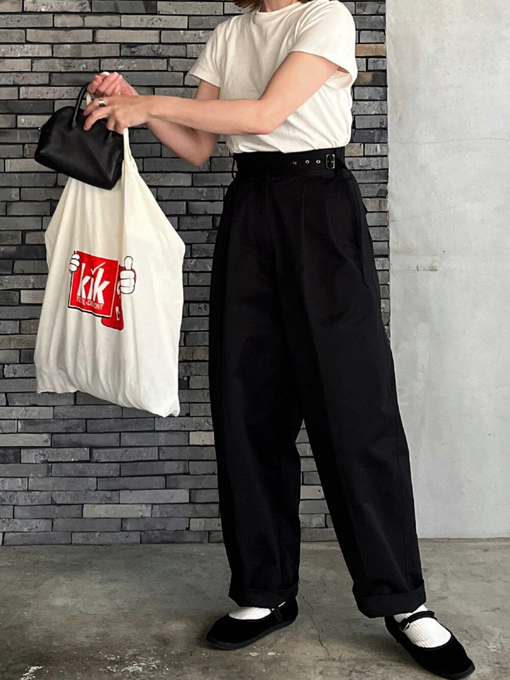 ブラック系のチノパンツ、ブラック系のその他シューズ、ブラック系のボストンバッグを着用したレディースの冬コーディネートの2枚目の写真