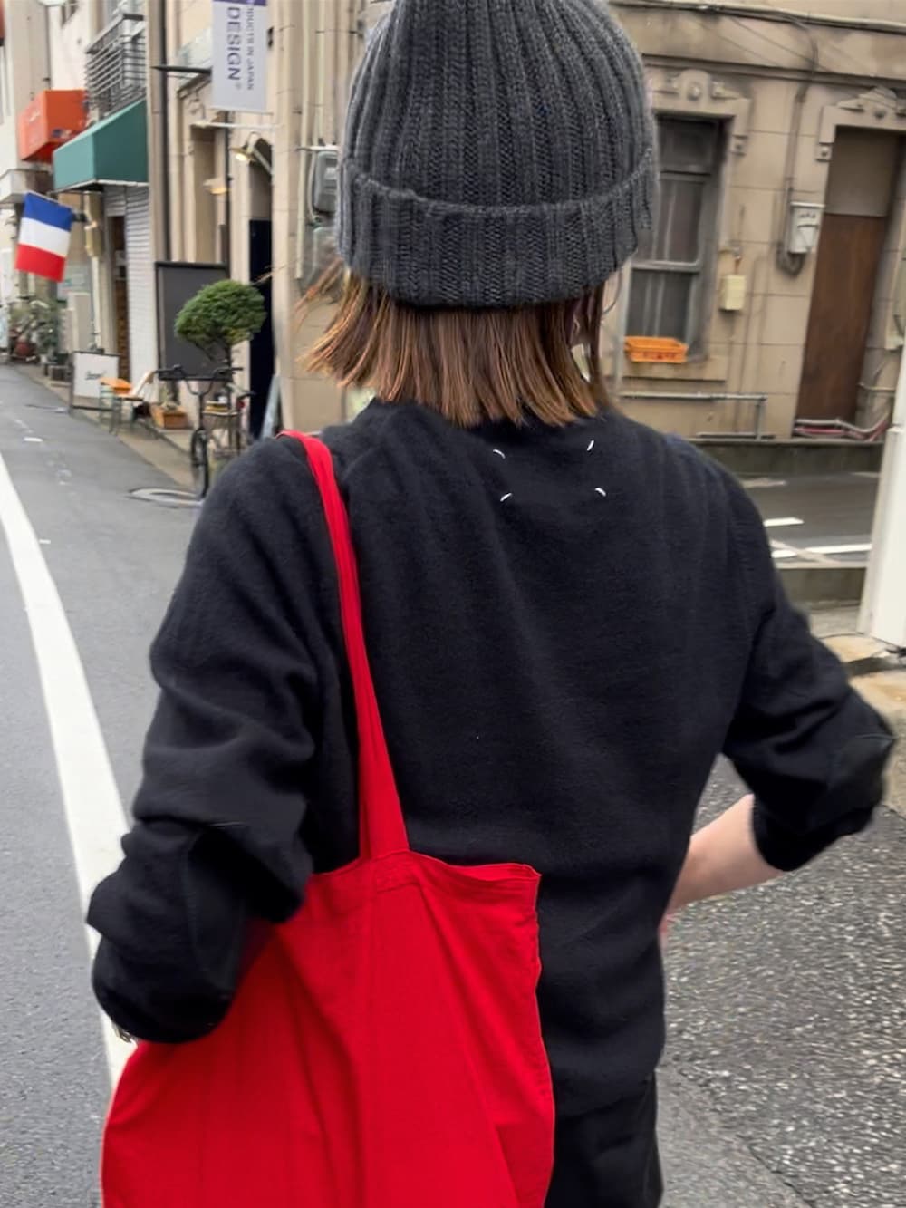 ブラック系のニット/セーター、ホワイト系のスニーカー、グレー系のニットキャップ/ビーニーを着用したレディースの秋コーディネートの3枚目の写真