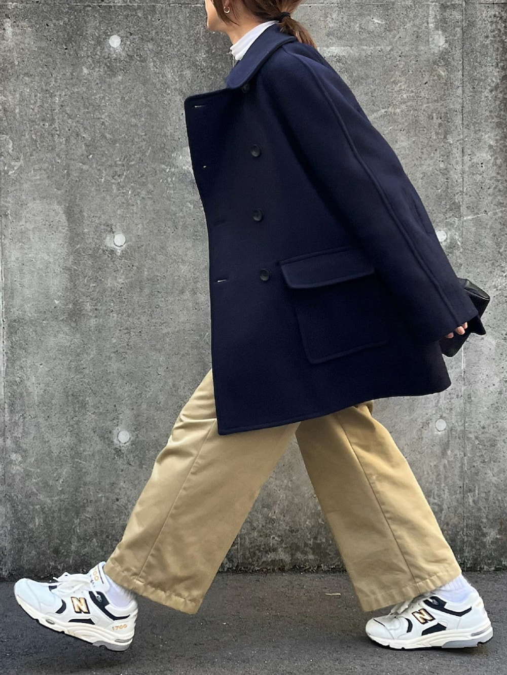 ブルー系のピーコート、ホワイト系のTシャツ/カットソー、ホワイト系のスニーカーを着用したレディースの冬コーディネートの3枚目の写真