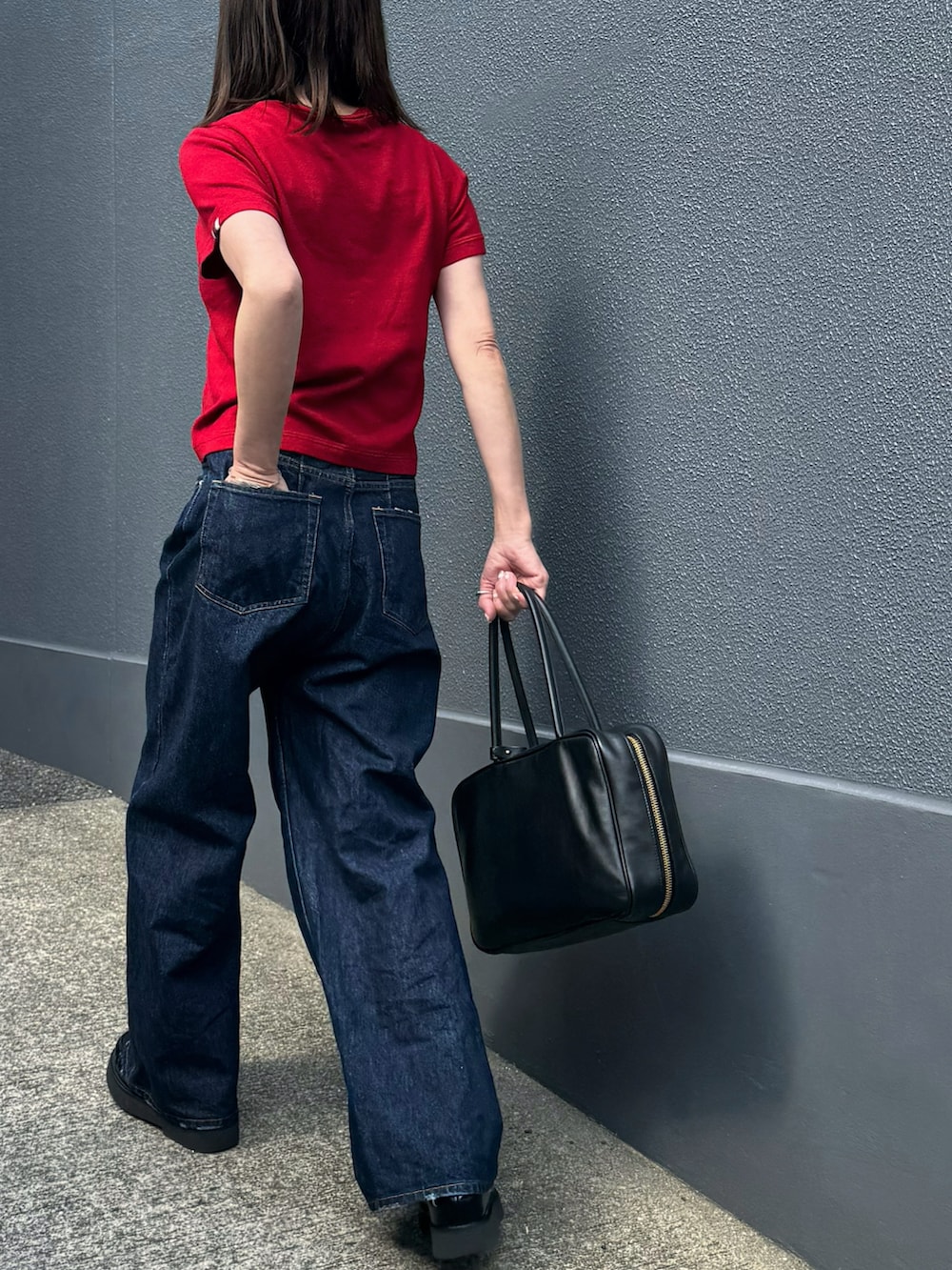 レッド系のニット/セーター、ブルー系のデニムパンツを着用したレディースの春コーディネートの5枚目の写真