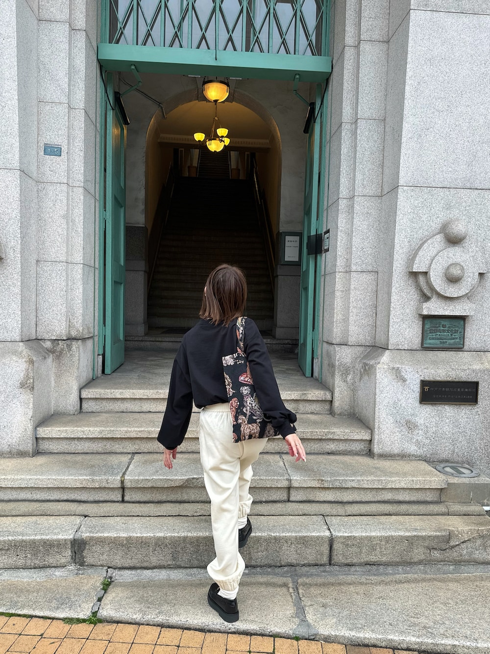 ブラック系のTシャツ/カットソー、ホワイト系のパンツ、ブラック系のローファーを着用したレディースの冬コーディネートの4枚目の写真