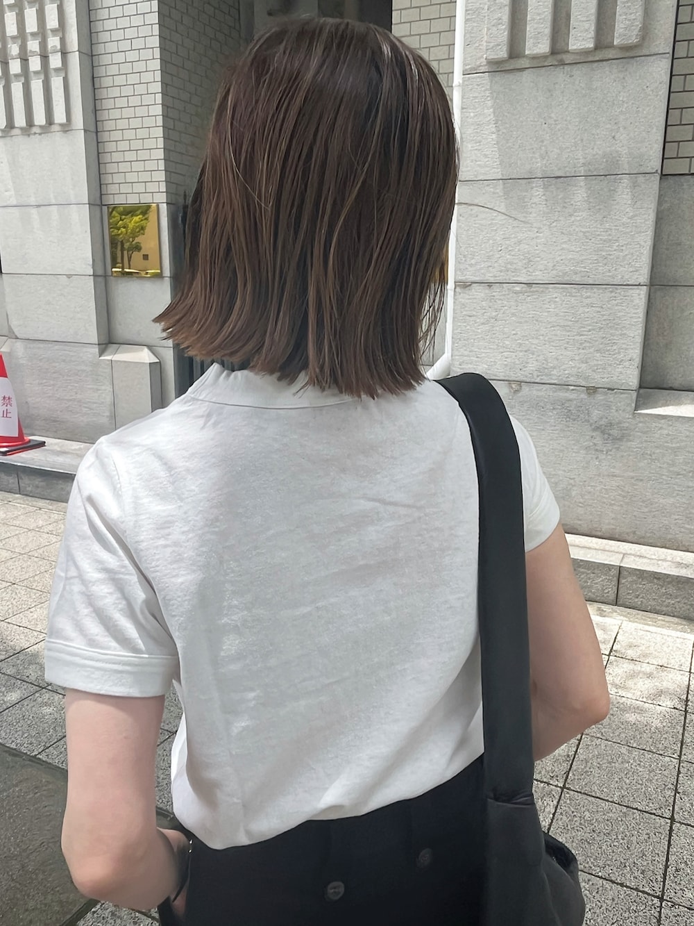 ホワイト系のTシャツ/カットソー、ブラック系のショルダーバッグ、ブラック系のサンダルを着用したレディースの夏コーディネートの3枚目の写真