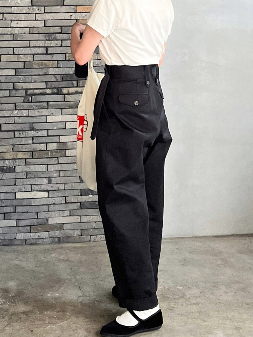 ブラック系のチノパンツ、ブラック系のその他シューズ、ブラック系のボストンバッグを着用したレディースの冬コーディネートの4枚目の写真