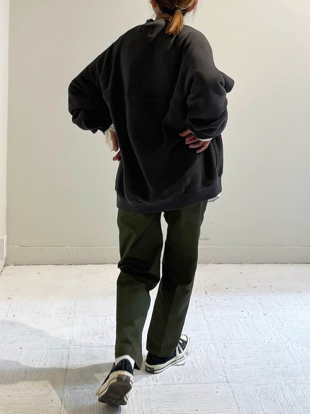 ブラック系のスウェット、グリーン系のパンツ、シルバー系のピアス（両耳用）を着用したレディースの秋コーディネートの4枚目の写真