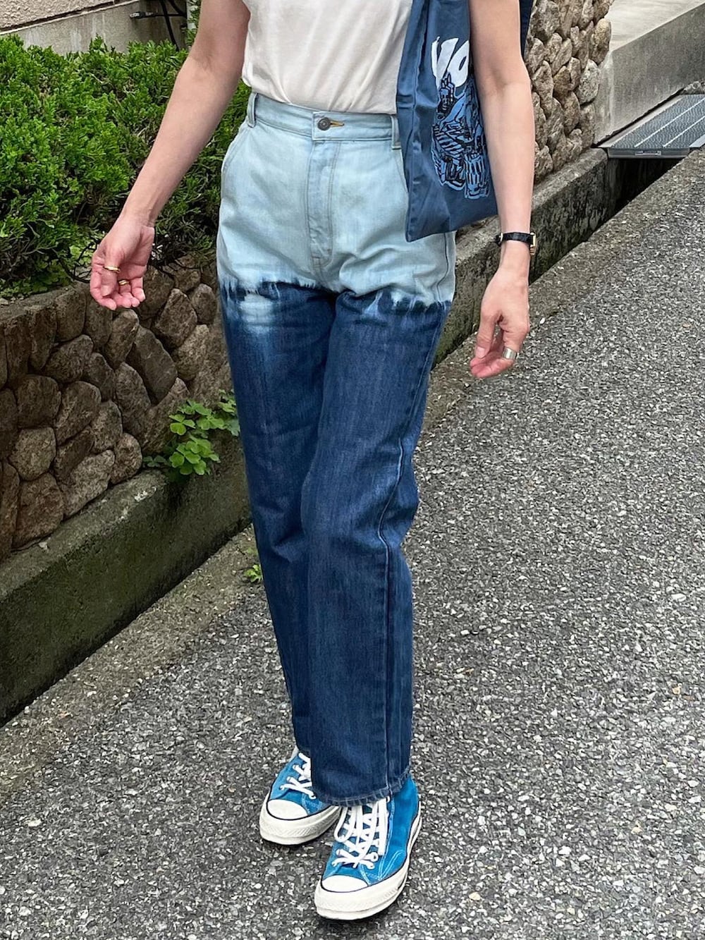 ブルー系のデニムパンツ、ブルー系のトートバッグを着用したレディースの春コーディネートの3枚目の写真