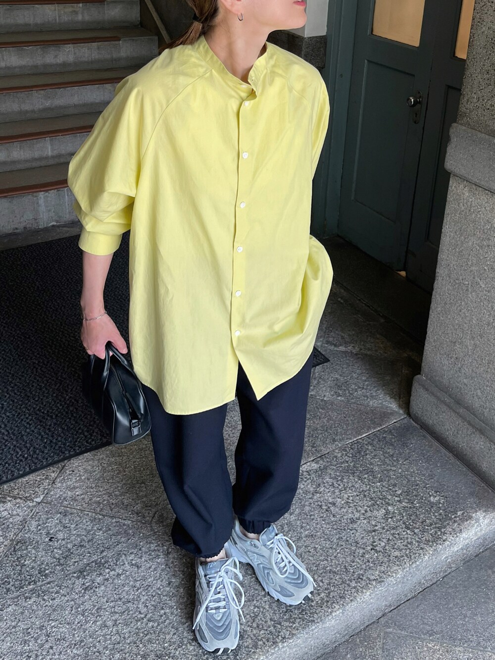 イエロー系のシャツ/ブラウス、ブルー系のスラックス、グレー系のスニーカーを着用したレディースの夏コーディネートの2枚目の写真