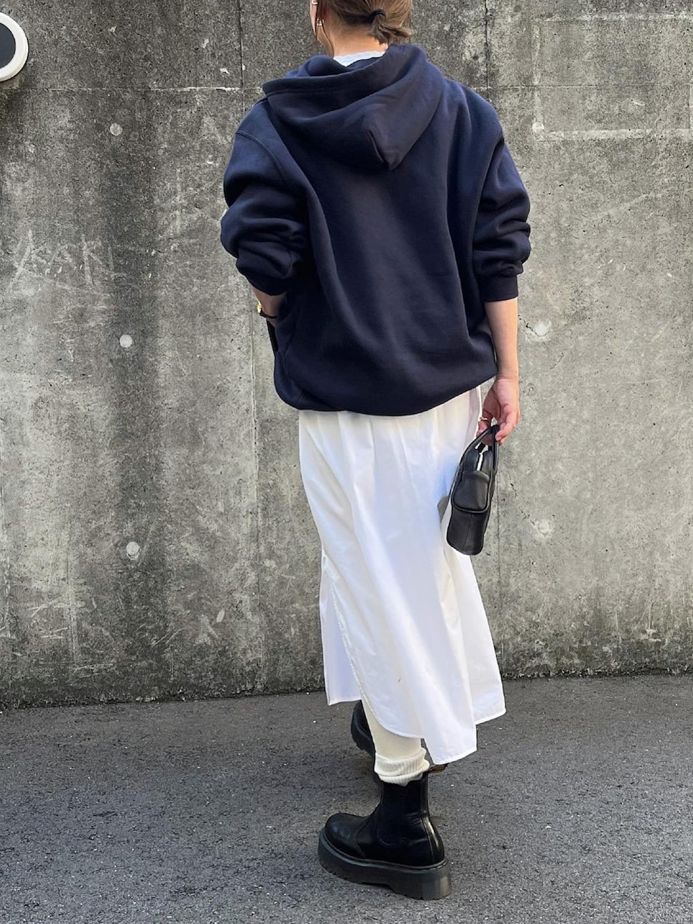 ホワイト系のシャツワンピース、ブラック系のボストンバッグ、ブラック系のブーツを着用したレディースの冬コーディネートの4枚目の写真