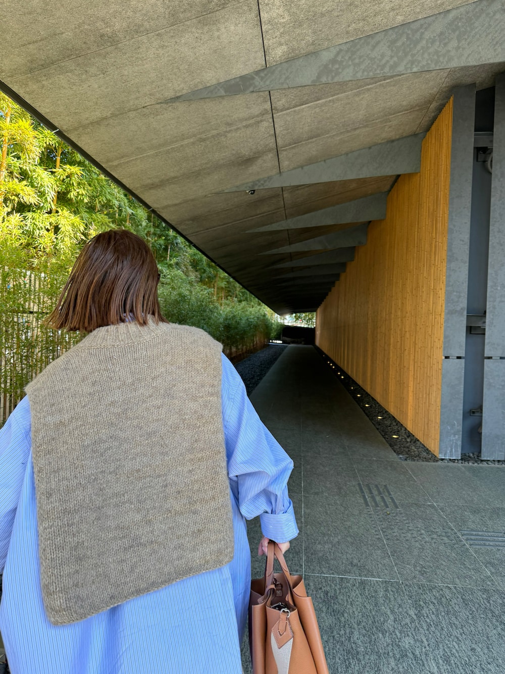 ブルー系のシャツ/ブラウス、ブルー系のデニムパンツ、ホワイト系のスニーカーを着用したレディースの春コーディネートの2枚目の写真