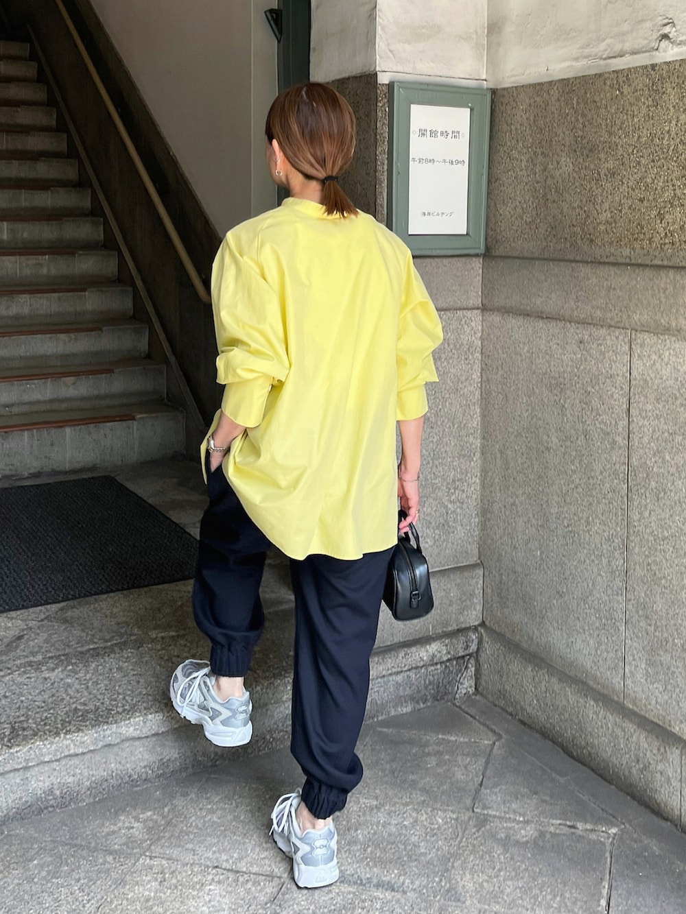 イエロー系のシャツ/ブラウス、ブルー系のスラックス、グレー系のスニーカーを着用したレディースの夏コーディネートの4枚目の写真