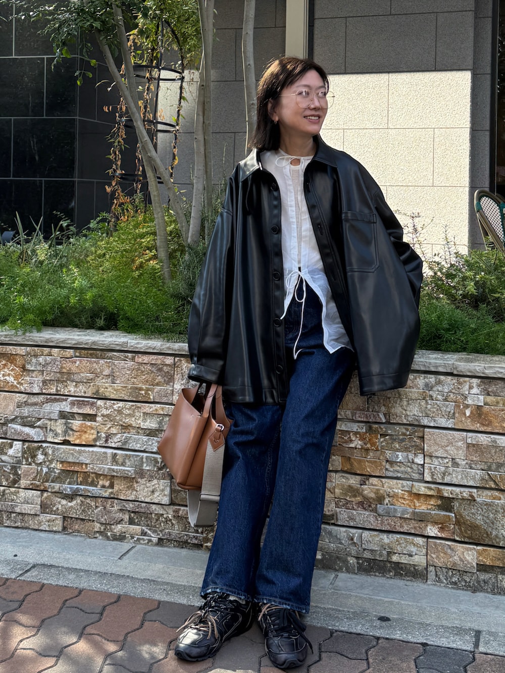 ブラック系のジャケット/アウター、ホワイト系のシャツ/ブラウス、ブルー系のデニムパンツを着用したレディースの秋コーディネートの3枚目の写真