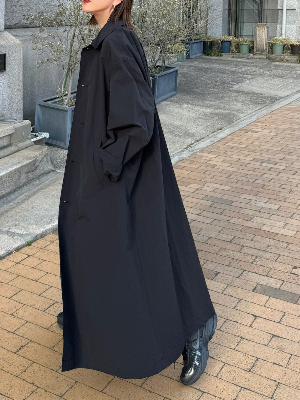 ブラック系のジャケット/アウター、ブラック系のスニーカー、ブラック系のボストンバッグを着用したレディースの春コーディネートの2枚目の写真