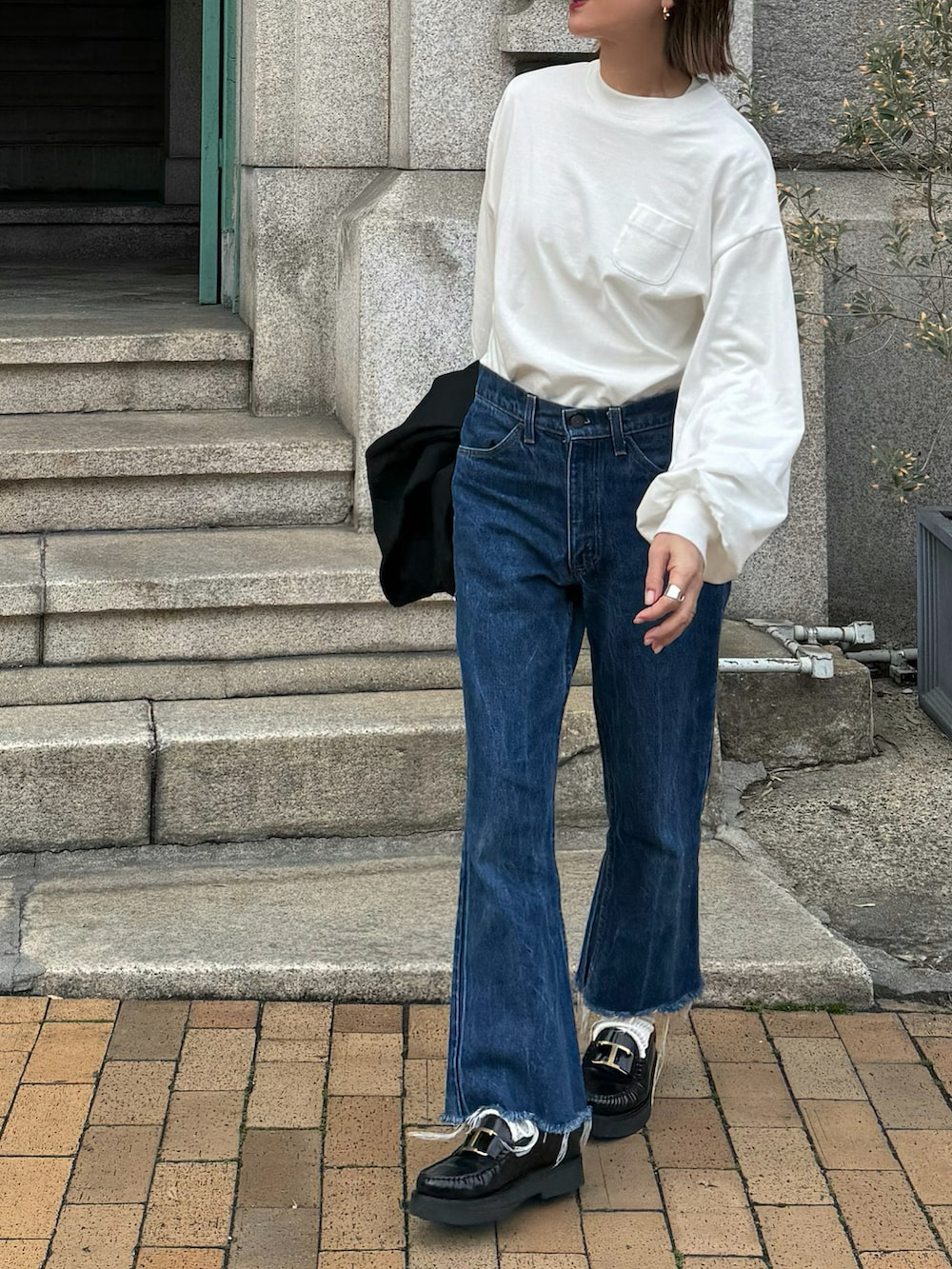 ホワイト系のTシャツ/カットソー、ブラック系のテーラードジャケット、ブラック系のローファーを着用したレディースの冬コーディネートの2枚目の写真