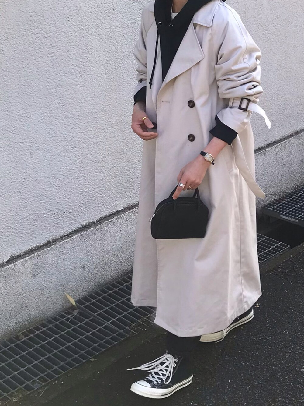 ホワイト系のトレンチコート、ブラック系のボストンバッグを着用したレディースの冬コーディネートの2枚目の写真