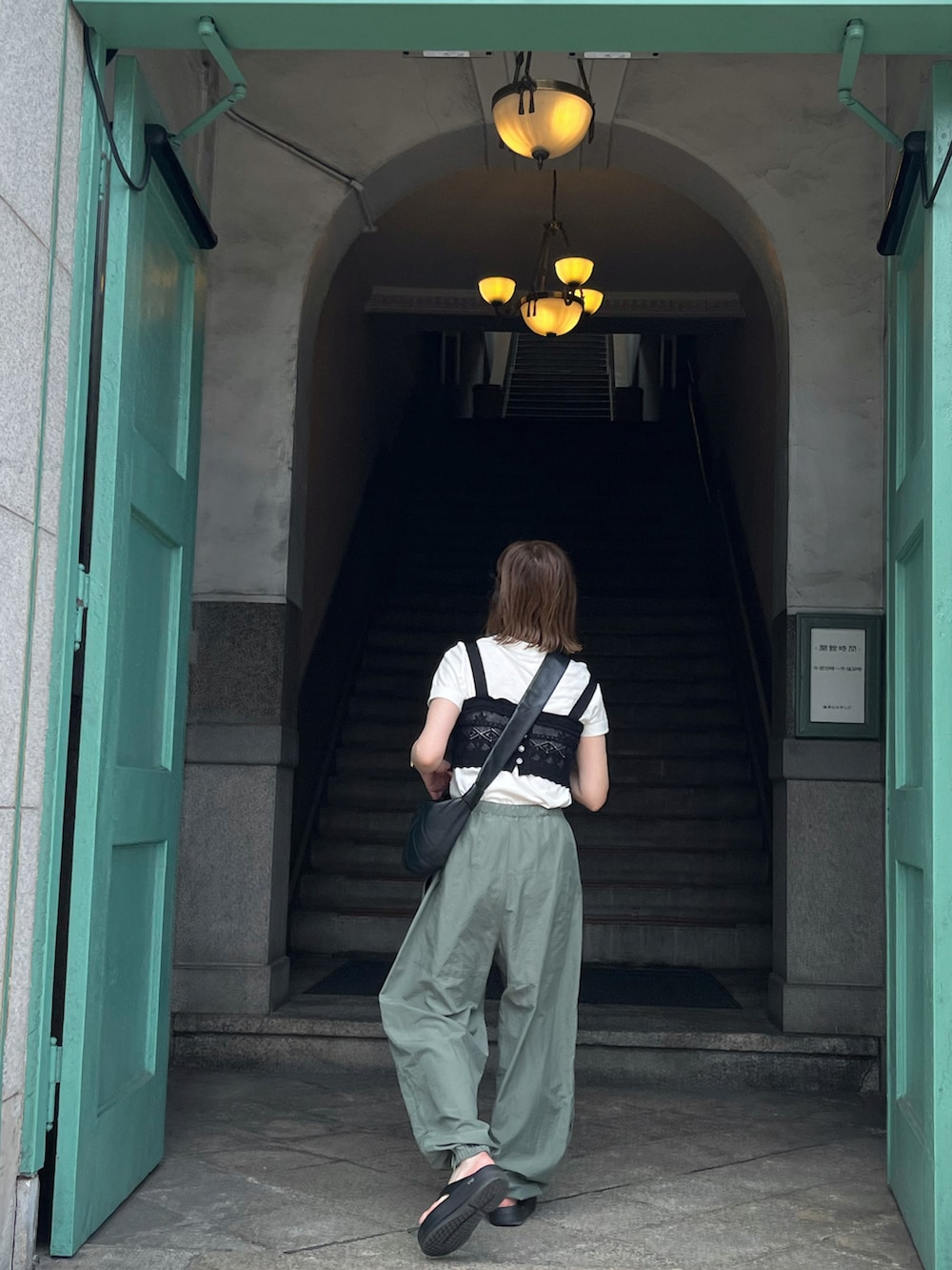 ブラック系のサンダル、ブラック系のショルダーバッグを着用したレディースの夏コーディネートの2枚目の写真