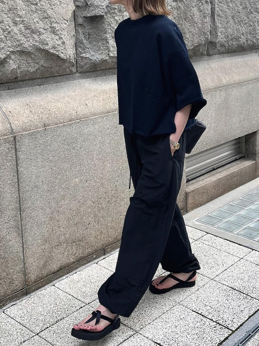 ブルー系のTシャツ/カットソー、ブラック系のパンツ、ブラック系のボストンバッグを着用したレディースの夏コーディネートの2枚目の写真