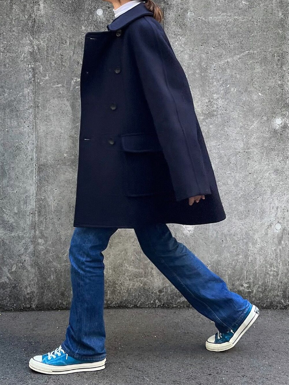 ブルー系のピーコート、ホワイト系のTシャツ/カットソー、ブラック系のボストンバッグを着用したレディースの冬コーディネートの4枚目の写真