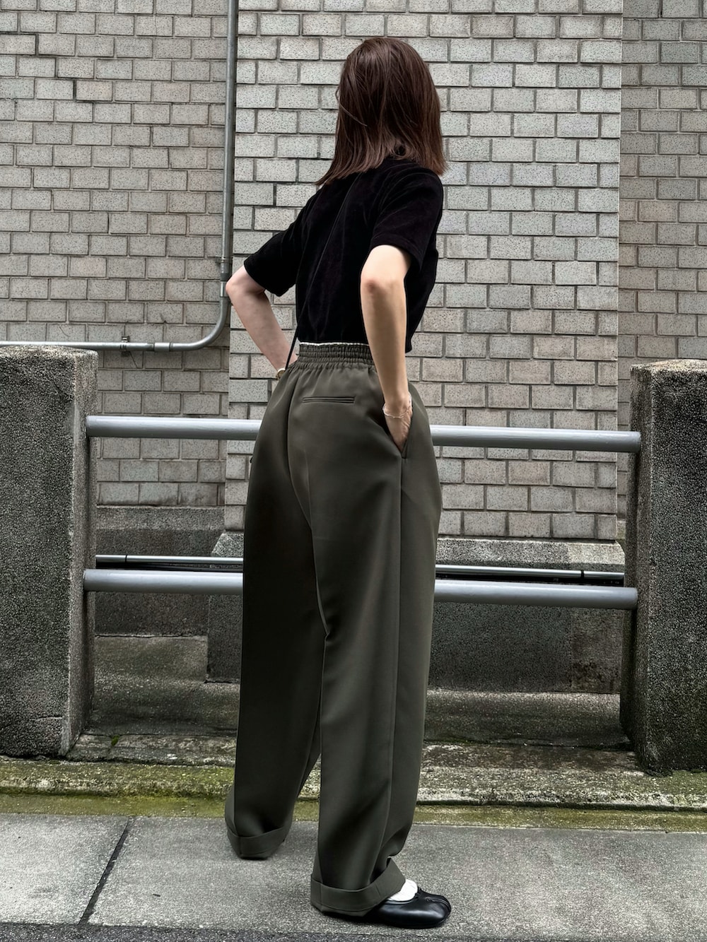 ブラック系のTシャツ/カットソー、グリーン系のパンツ、ブラック系のバレエシューズを着用したレディースの夏コーディネートの3枚目の写真