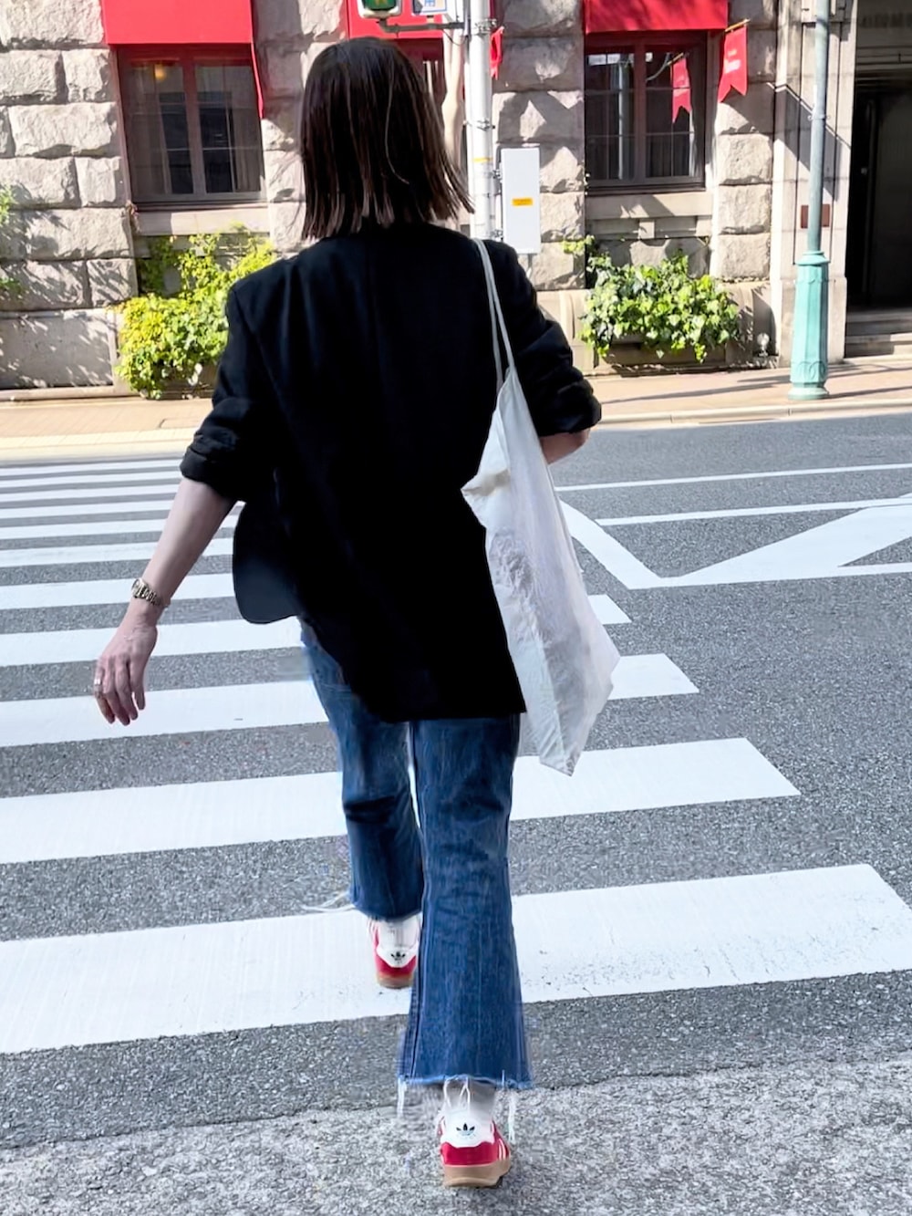 ブラック系のテーラードジャケット、ホワイト系のTシャツ/カットソー、レッド系のスニーカーを着用したレディースの秋コーディネートの2枚目の写真