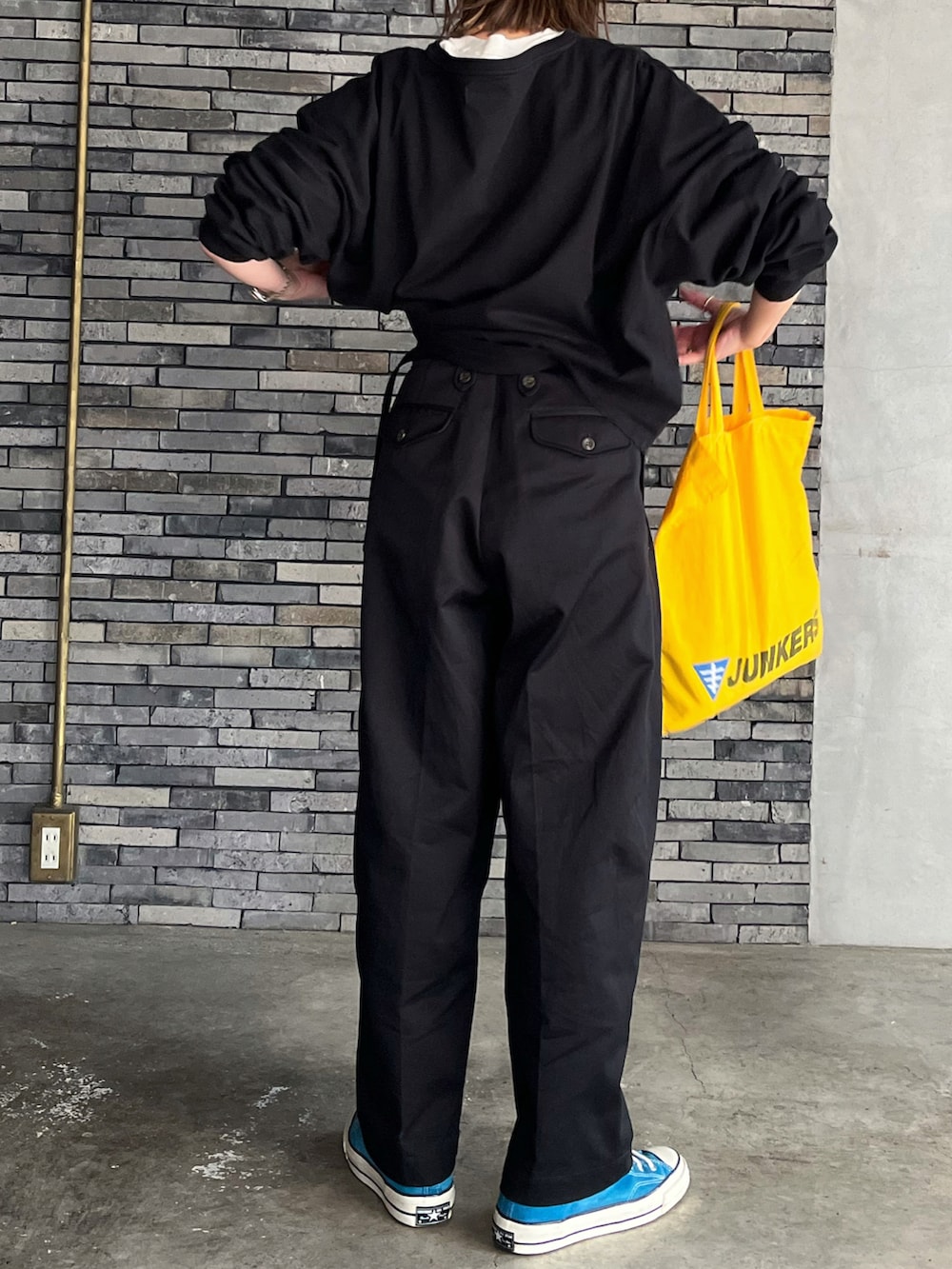 ブラック系のチノパンツ、ブルー系のスニーカー、シルバー系のピアス（両耳用）を着用したレディースの春コーディネートの4枚目の写真