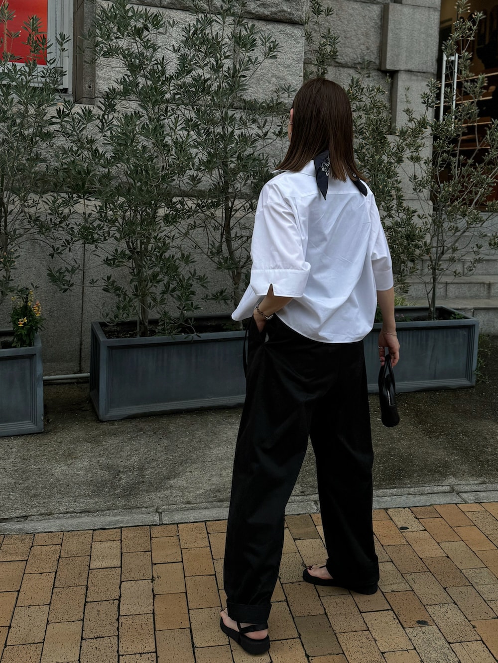 ホワイト系のシャツ/ブラウス、ブラック系のチノパンツ、シルバー系のブレスレットを着用したレディースの夏コーディネートの4枚目の写真