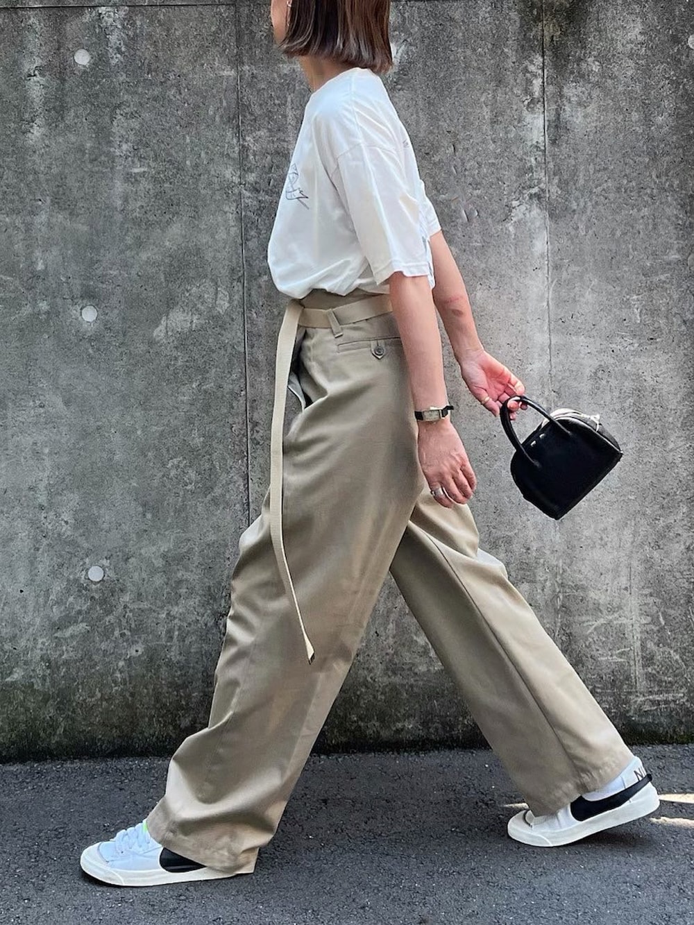 ベージュ系のその他パンツ、ブラック系のボストンバッグ、ホワイト系のスニーカーを着用したレディースの夏コーディネートの2枚目の写真