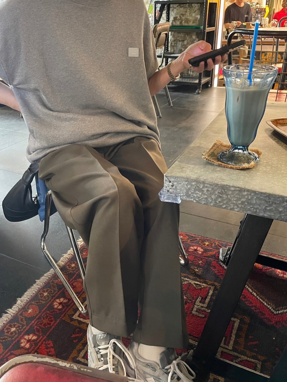 グレー系のスウェット、グリーン系のパンツ、グレー系のスニーカーを着用したレディースの夏コーディネートの4枚目の写真