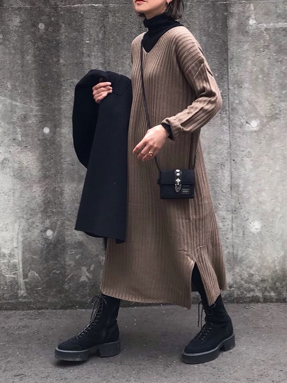 ブラウン系のワンピース、ブラック系のブーツ、ブラック系のタイツ/ストッキングを着用したレディースの冬コーディネートの2枚目の写真