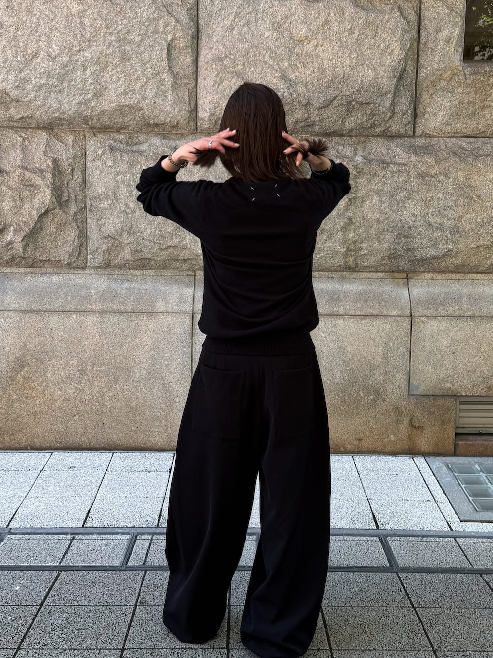 ブラック系のニット/セーター、ブラック系のバレエシューズ、ブラック系のパンツを着用したレディースの夏コーディネートの3枚目の写真