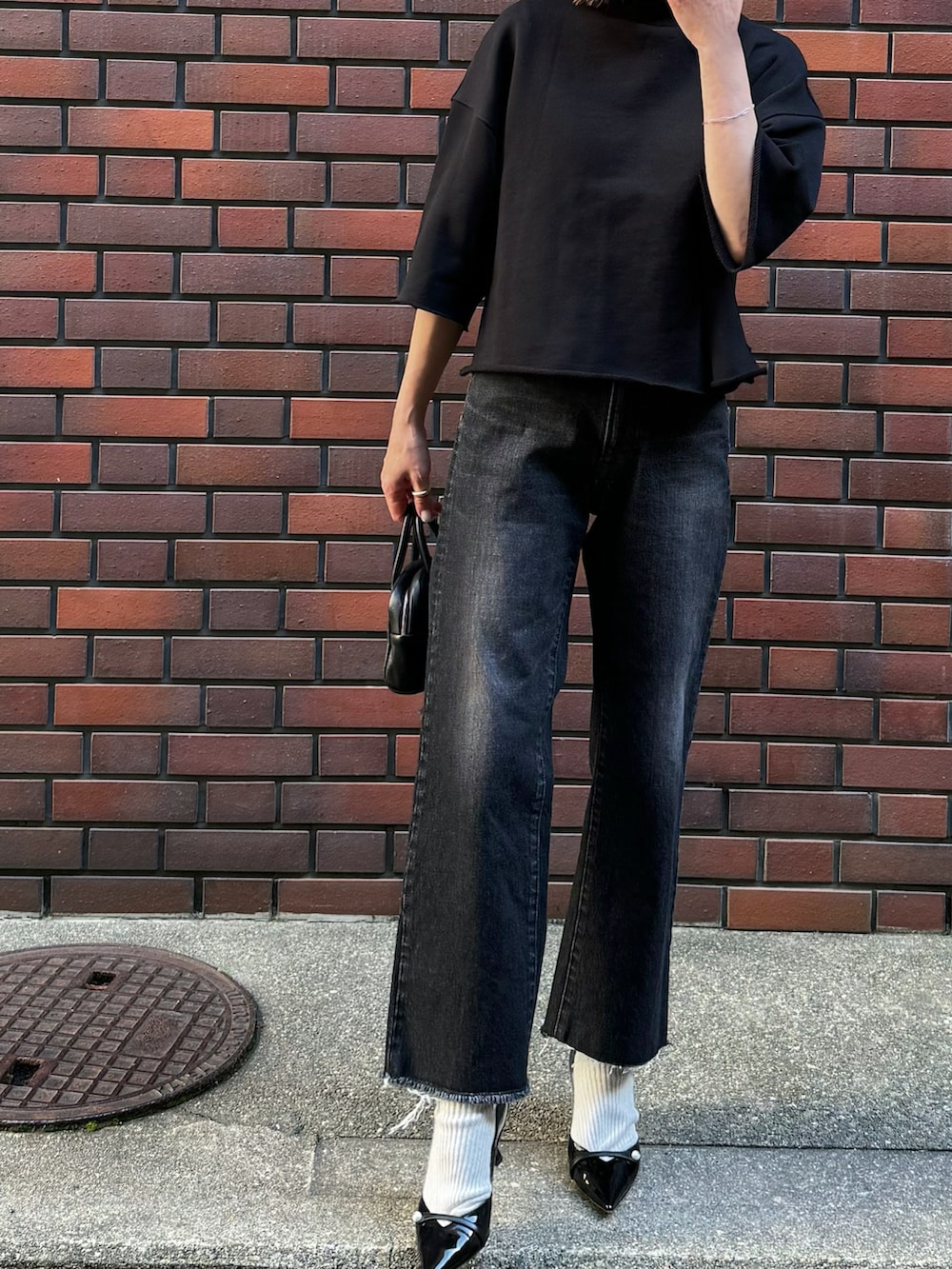 ブラック系のTシャツ/カットソー、ブラック系のデニムパンツ、シルバー系のリングを着用したレディースの春コーディネートの3枚目の写真