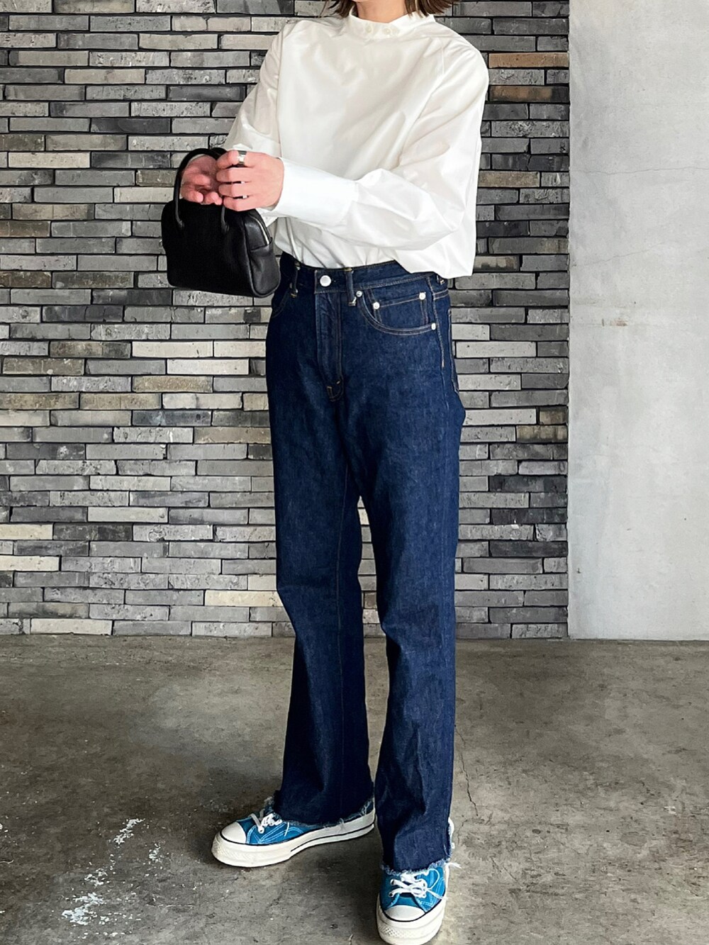 ホワイト系のシャツ/ブラウス、ブラック系のボストンバッグ、ブルー系のデニムパンツを着用したレディースの春コーディネートの5枚目の写真