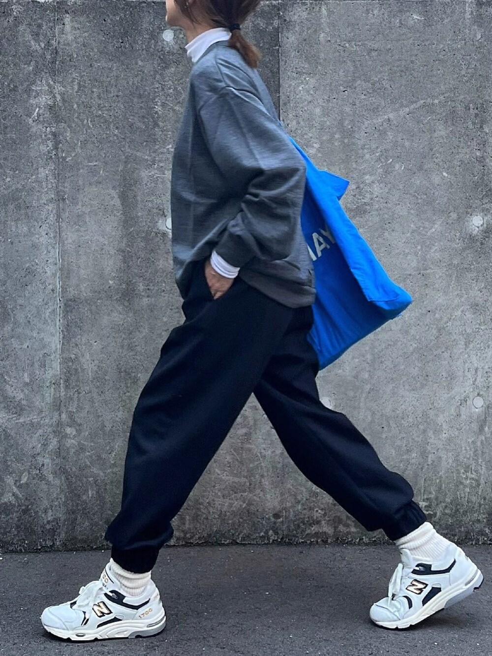 グレー系のトップス、ホワイト系のTシャツ/カットソー、ブルー系のスラックスを着用したレディースの冬コーディネートの2枚目の写真