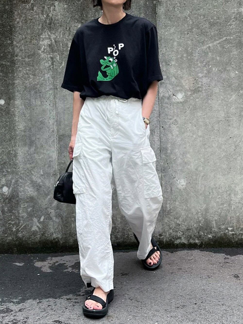 ブラック系のTシャツ/カットソー、ホワイト系のその他パンツ、ブラック系のサンダルを着用したレディースの夏コーディネートの2枚目の写真