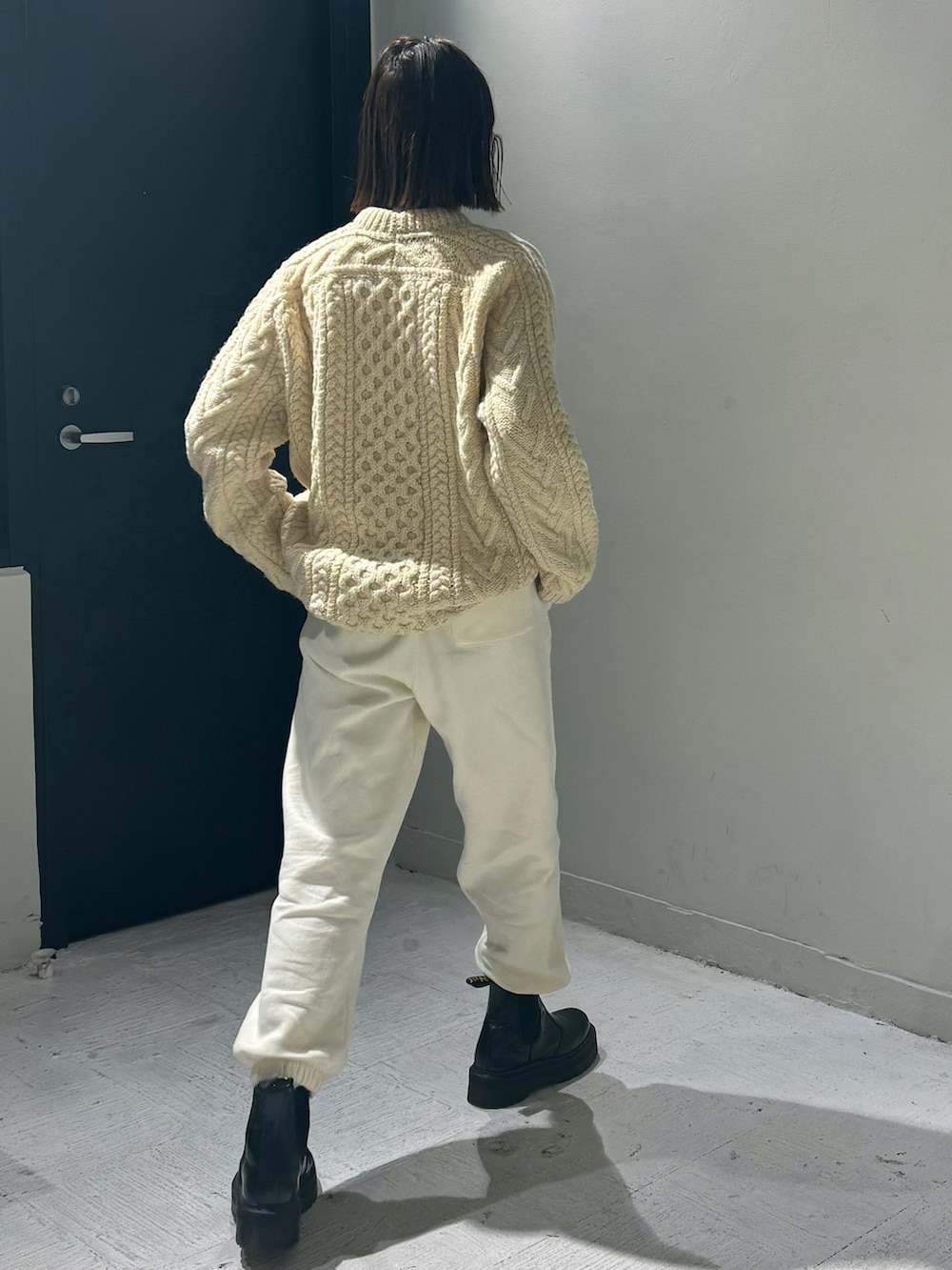 ベージュ系のダウンジャケット/コート、ホワイト系のスウェットパンツ、ブラック系のブーツを着用したレディースの冬コーディネートの3枚目の写真