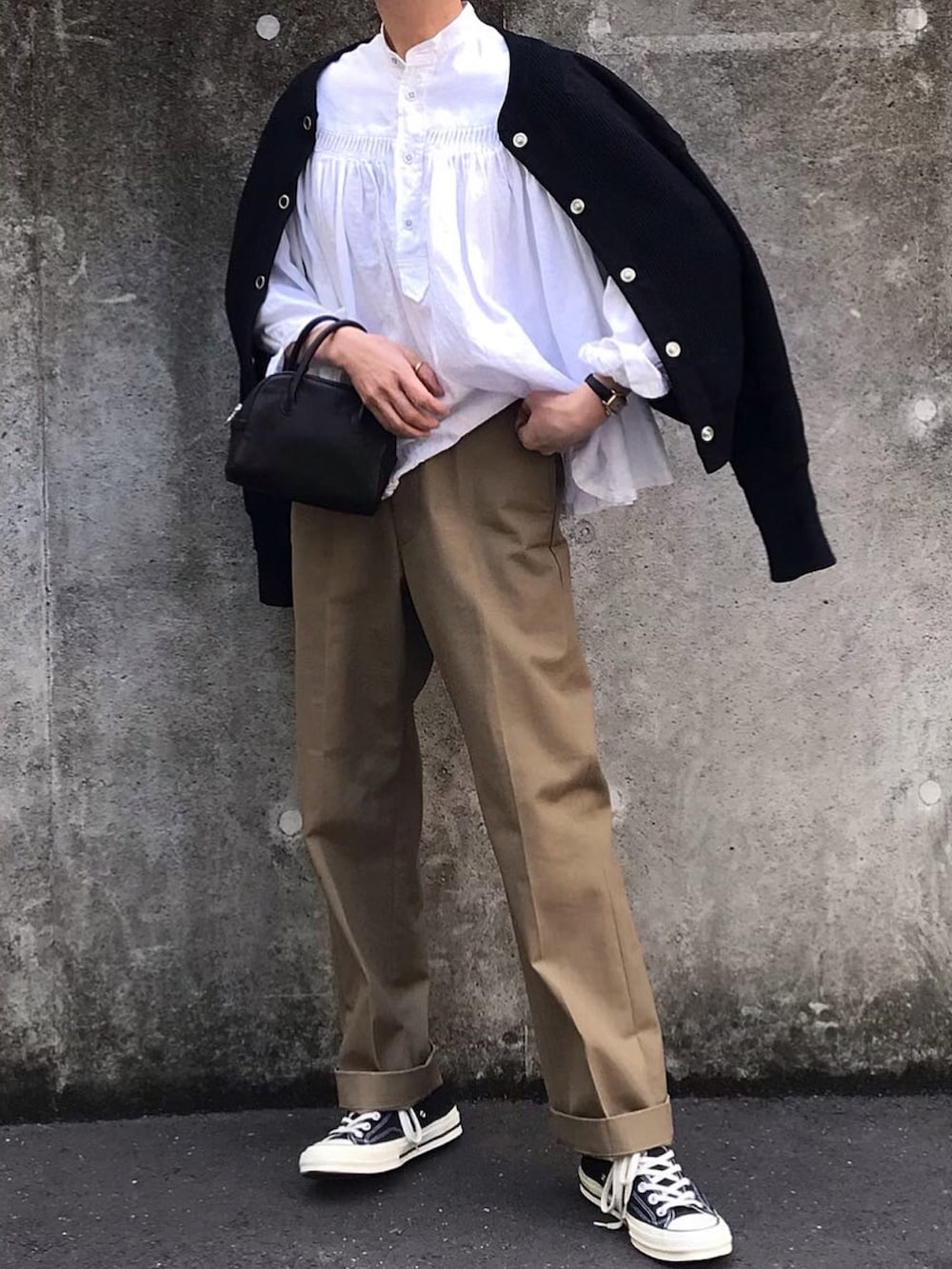 ブラック系のカーディガン/ボレロ、ベージュ系のチノパンツ、ホワイト系のシャツ/ブラウスを着用したレディースの春コーディネートの2枚目の写真