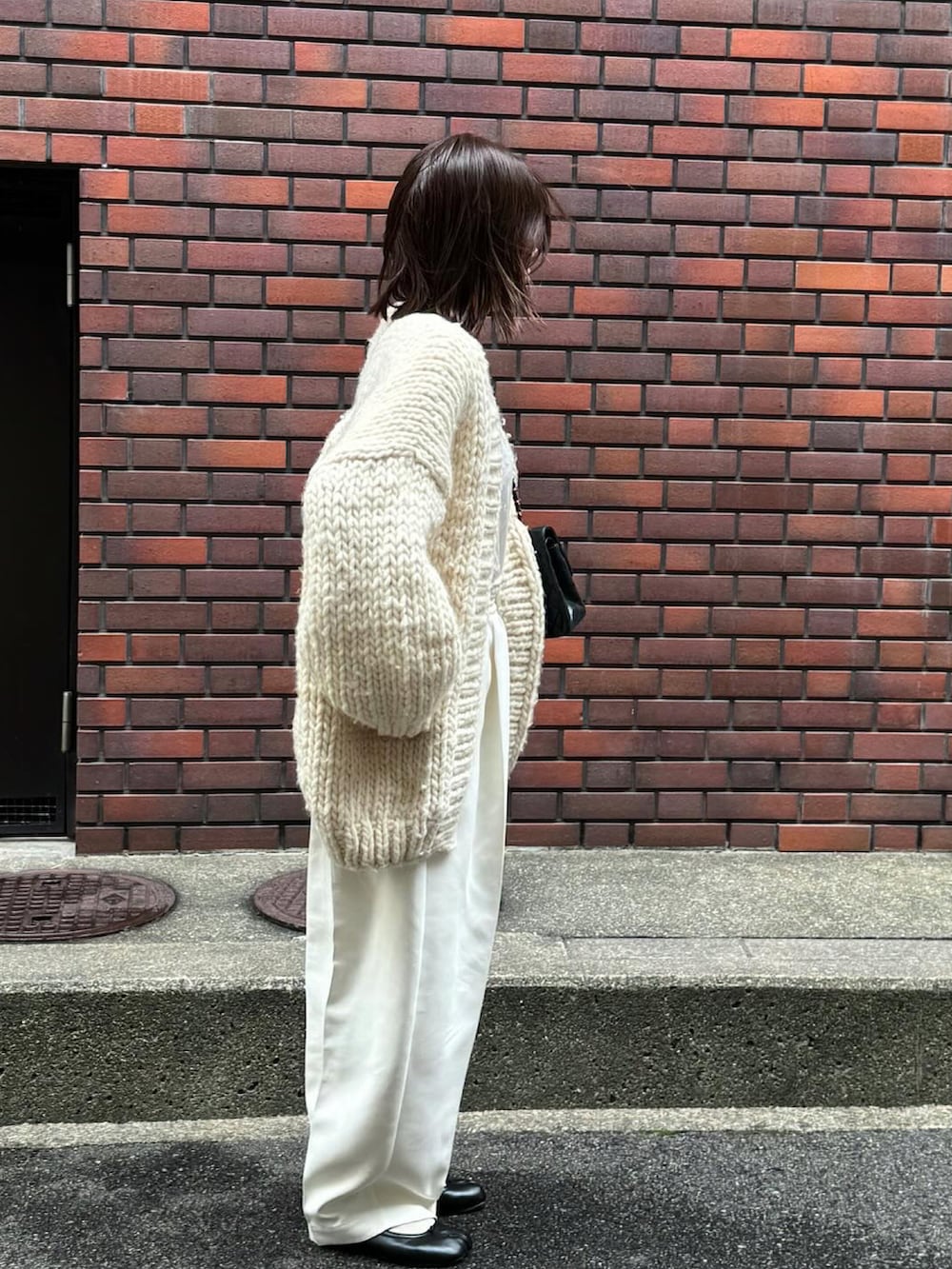 ホワイト系のパンツ、ブラック系のバレエシューズ、シルバー系のリングを着用したレディースの冬コーディネートの4枚目の写真