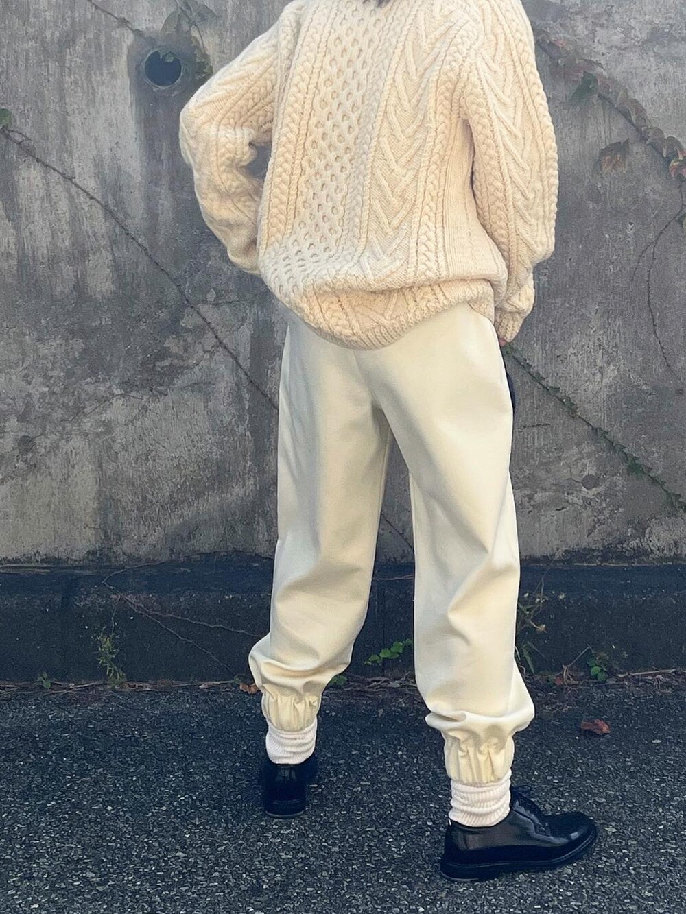 ホワイト系のパンツ、ブラック系のドレスシューズ、ブラック系のボストンバッグを着用したレディースの秋コーディネートの3枚目の写真