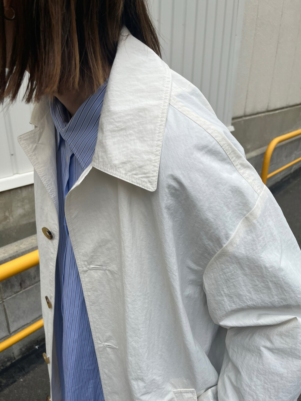 ブルー系のシャツ/ブラウス、ホワイト系のジャケット/アウター、レッド系のスニーカーを着用したレディースの冬コーディネートの4枚目の写真