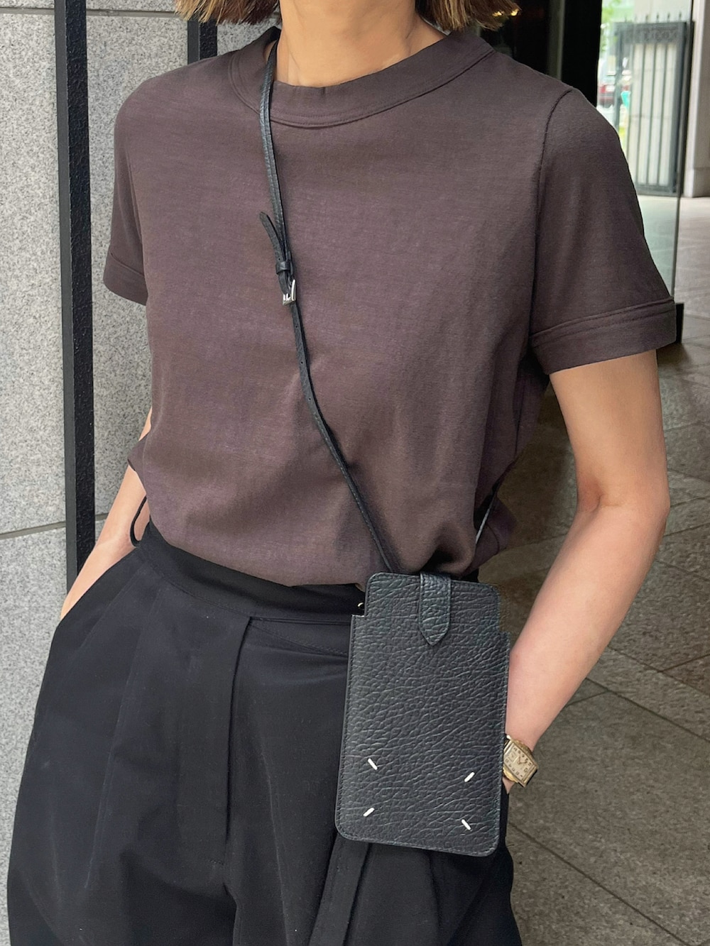 ブラウン系のTシャツ/カットソー、ブラック系のチノパンツ、ブラック系のサンダルを着用したレディースの夏コーディネートの5枚目の写真