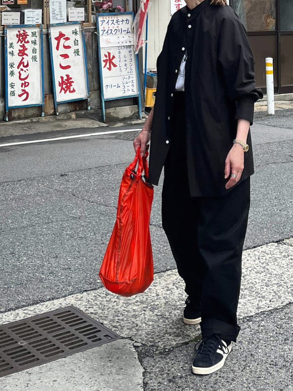 ブラック系のシャツ/ブラウス、ブラック系のチノパンツ、ブラック系のスニーカーを着用したレディースの春コーディネートの3枚目の写真